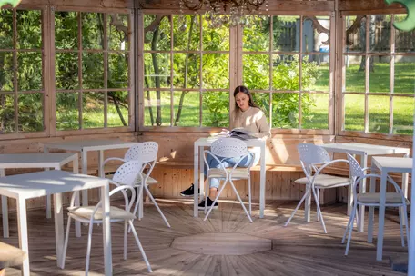 Junge Frau beim Lesen im Pavillon des Hotel Royal Hinterhuber