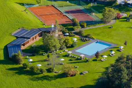 Gartenanlage mit Tennisplätzen, Pool und Liegewiese beim Hotel Royal Hinterhuber