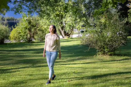 Junge Frau beim Lustwandeln im Garten des Hotel Royal Hinterhuber