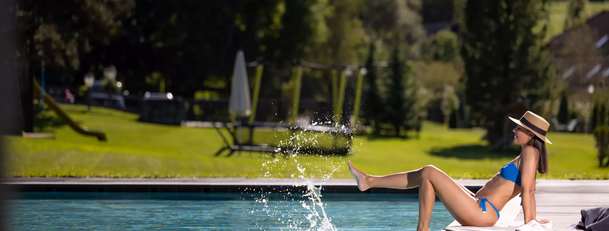 Junge Frau am Pool im Garten des Hotel Royal Hinterhuber